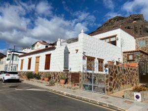een wit gebouw op een straat met een berg bij Beautiful beach house in traditional Canarian style in Puerto de Mogán
