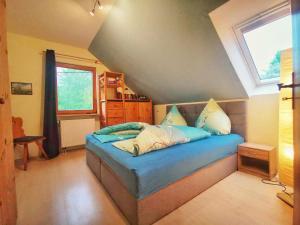 a bedroom with a bed with blue sheets and a window at Ferienwohnung Gisela in Steinigtwolmsdorf