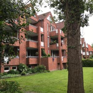a large brick building with a green lawn in front of it at Ferienwohnung Thedo in Bad Zwischenahn