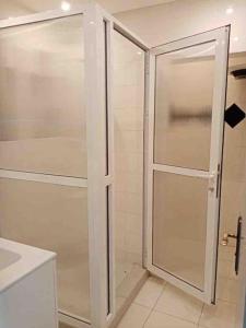 eine Dusche mit Glastür im Bad in der Unterkunft Appartement au hyper centre Cosy et typique in Agadir
