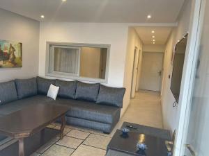ein Wohnzimmer mit einem blauen Sofa und einem Tisch in der Unterkunft Appartement au hyper centre Cosy et typique in Agadir