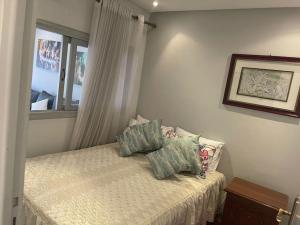 ein Schlafzimmer mit einem Bett mit zwei Kissen und einem Fenster in der Unterkunft Appartement au hyper centre Cosy et typique in Agadir