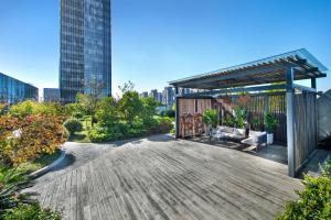 a wooden deck with a pergola in a city at Somerset Baitang Suzhou in Suzhou