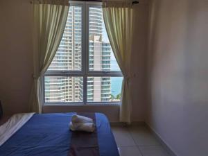 a bedroom with a blue bed and a large window at Mansion One Luxurious Seaview Vacation Homes in George Town