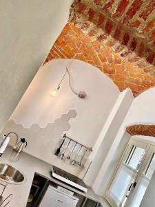 a kitchen with a brick wall and a ceiling at Acini e Rose in Montalenghe