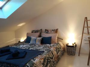 ein Schlafzimmer mit einem Bett mit einer blauen Decke und einer Leiter in der Unterkunft les Métras in Ceyzériat