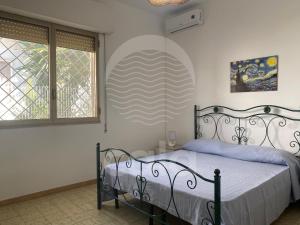 a bedroom with a bed and two windows at Villa Tortuga By Cala Salento in Torre Lapillo