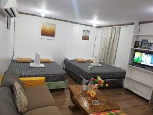 a living room with two beds and a couch at Okoy Guest House in Bantayan Island