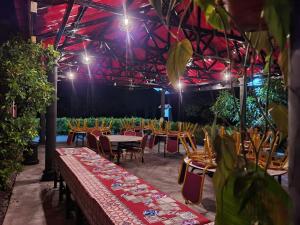 a group of tables and chairs in a room with lights at AsiaCamp - Cabin Sungai Sireh in Tanjung Karang
