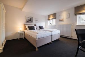 um quarto com uma grande cama branca num quarto em Eichhorns em Niebüll