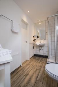 a bathroom with a toilet and a sink and a mirror at Eichhorns in Niebüll