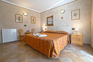 1 dormitorio con 1 cama grande con colcha de color naranja en Residence Grand Hotel SIVA - Adults Only, en Santo Stefano dʼAveto