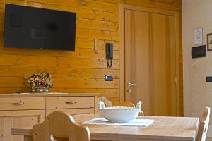 - une table à manger avec une télévision sur un mur en bois dans l'établissement Residence Grand Hotel SIVA - Adults Only, à Santo Stefano dʼAveto