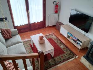sala de estar con sofá, TV y mesa en Chalet turístico La Jenduda, en Ojedo