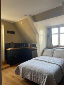 een slaapkamer met een groot bed en een keuken bij Boven-Langs in Diepenheim