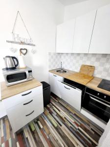 a kitchen with white cabinets and a kitchen rug at Apartmani Nika in Slatine