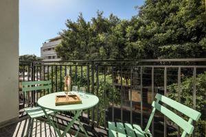 patio con mesa y sillas en el balcón en Pixel Dizengoff Square - Smart Hotel by Loginn Tel Aviv en Tel Aviv