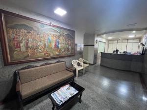 a living room with a couch and a painting on the wall at Sri Durgamba Lodge in Bangalore