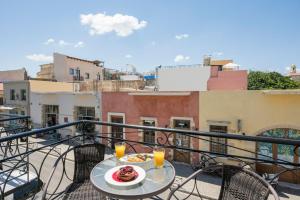 a table with a plate of food on a balcony at Porto Orion Studios in Chania Town