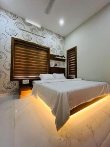 a bedroom with a large bed and a large window at Milaano Orchids, Service Villa, Kammana Mananthavady in Wayanad