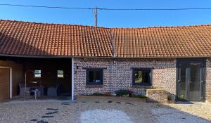 una casa de ladrillo con techo de baldosas rojas en La Suite Chambre d’hôtes Spa et Sauna, en Aire-sur-la-Lys