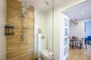 a bathroom with a shower and a toilet at Apartamenty Kapitańskie in Darłówko