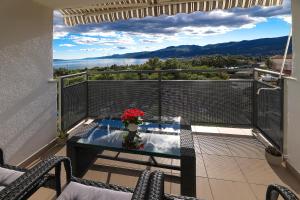 een balkon met een tafel en uitzicht op de bergen bij Apartment Leon - Sea View in Rijeka