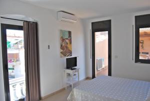 1 dormitorio con 1 cama y TV en una mesa en Apartaments Fonda Comerç en Torroella de Montgrí