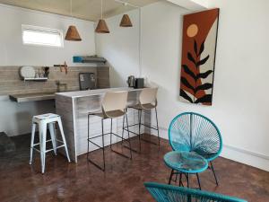 eine Küche mit 2 Stühlen, einer Theke und einer Bar in der Unterkunft Ti Pavillon in Rodrigues Island