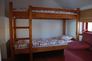 two bunk beds in a room with a couch at Hostel Pritsukas in Orissaare