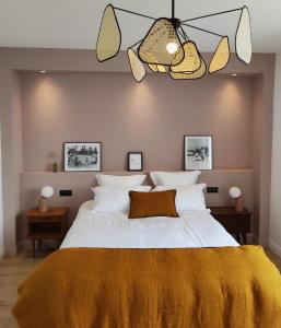 a bedroom with a large bed with a yellow blanket at Appart hôtel & Spa La Villa du Port in Vannes