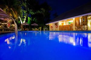 a large blue swimming pool at night at Indian Ocean Lodge in Grand'Anse Praslin