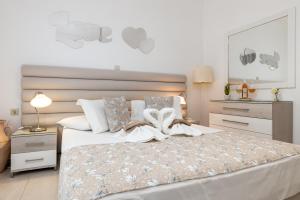 帕罗奇亚Panos Luxury Studios的卧室里有一张大床，床单和枕头都是白色的