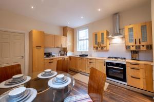 a kitchen with a glass table and wooden cabinets at The Chestnut - Liverpool City - L7 in Liverpool