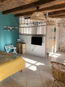 a living room with a bed and a tv at Le Clos Bô-m in Marignieu