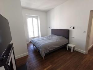 een slaapkamer met een bed in een kamer met een tv bij 10 rue Carnot in Montceau-les-Mines