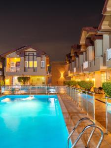 una piscina frente a algunos edificios por la noche en Alvanti Residences, en Accra