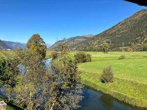 een rivier in een veld met bergen op de achtergrond bij Appartement Imbachhorn in Zell am See +13 foto's