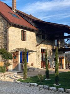 une maison en pierre avec un banc devant elle dans l'établissement Le Clos Bô-m, à Marignieu