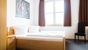 a bed in a room with a window at Hotel Am Hopfenmarkt in Rostock