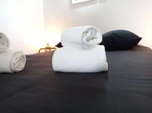 une pile de serviettes assises au-dessus d'un lit dans l'établissement Charmant gîte indépendant au calme tout confort, à Barbaste