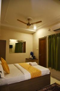 a bedroom with a bed and a ceiling fan at Bluebells Varanasi in Varanasi