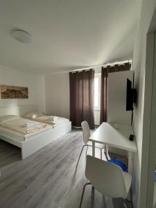 um quarto com uma cama, uma mesa e cadeiras em Tyros Hotel und Gästehaus am Weidendamm em Hanôver