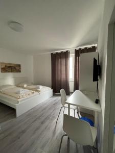 a room with a bed and a table and chairs at Tyros Hotel und Gästehaus am Weidendamm in Hannover