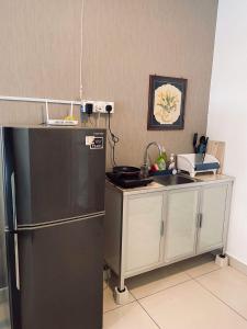 a kitchen with a black refrigerator and a sink at Summer Suites in George Town