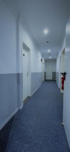 an empty hallway of an office building with a door at Tyros Hotel und Gästehaus am Weidendamm in Hannover