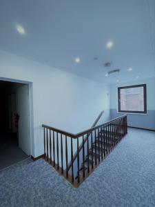 an empty room with a staircase with a blue light at Tyros Hotel und Gästehaus am Weidendamm in Hannover