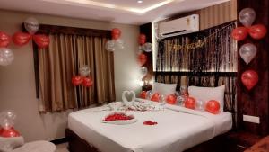 バンガロールにあるAl Noor Palaceの赤と白の風船が備わるベッド1台が備わる客室です。