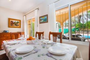 a dining room with a table with plates and glasses at Villa La Martina - PlusHolidays in Calpe