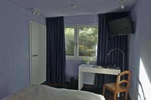 a bedroom with a bed and a desk and a window at quartier26 in Nuremberg